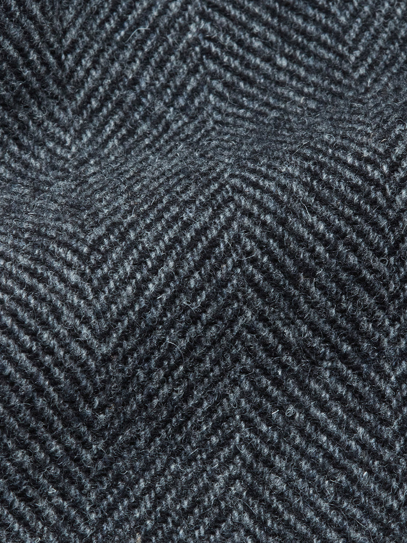 Close-up of dark gray herringbone fabric, showcasing the textured zigzag weave and soft wool fibers featured in Blue de Gênes Kyoto Pant - Black Pattern.