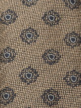 Close-up of the Nekutaki Tie #E - Sand Pattern by Blue de Gênes, showcasing textured brown fabric with a classic style and a repeating pattern of small dark blue and white floral circles.