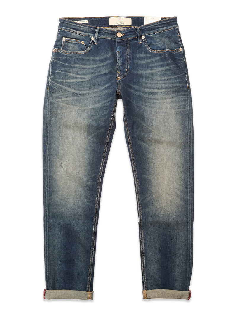 Blue de Gênes Vinci Dark Vintage Jeans in mid blue denim feature comfort stretch, a slightly faded look, rolled-up cuffs, classic five-pocket styling, and visible stitching details.