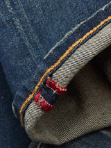 Close-up of the cuff on Blue de Gênes Vinci Dark Vintage Jeans in mid-blue denim, highlighting the comfort stretch fabric, selvedge edge with red and white stitching, and contrasting yellow seam detail.