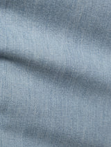 Close-up of mid blue comfort stretch denim from Blue de Gênes BGvinci Trueblue Jeans, highlighting the visible weave pattern and a soft diagonal crease across the fabric.