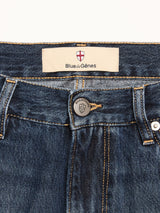Close-up of the waistband on Blue de Gênes BGmarco Rowan Jeans - Used, featuring a metal button with shield logo and a Blue de Gênes label decorated with a red and white cross emblem.