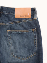 Close-up of the back pocket and waistband of BGmarco Rowan Jeans - Used by Blue de Gênes, showing a brown leather patch with the brand name, shield logo, and classic 5-pocket denim design.