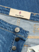 Close-up of BGrepi Misto Jeans - Med Used by Blue de Gênes, featuring the branded waistband label and three black shield-embossed buttons against denim fabric.