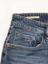 Close-up of BGvinci Striker Jeans - Dark Distress by Blue de Gênes: blue comfort stretch denim, regular fit, front pocket with decorative shield emblem, and a Made in Italy label with Italian flag on the waistband.