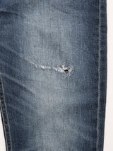 A close-up of Blue de Gênes BGvinci Striker Jeans - Dark Distress, showcasing a frayed rip and distressed fabric on the thigh, crafted in Italy with a regular fit.