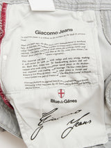 The inside label of BGgiacomo Color Jeans - Dolphin Grey by Blue de Gênes features detailed printed text about origin, relaxed loose fit design, and fabric, plus the Blue de Gênes logo and a printed signature at the bottom.