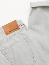 The BGgiacomo Color Jeans - Dolphin Grey by Blue de Gênes are relaxed loose fit, rigid light grey denim with a brown leather brand label above the back pocket. Folded to display the label, pocket stitching, and cuffed hem.