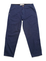 The BGpalco Toll Pants - Navy Stripe by Blue de Gênes feature white vertical pinstripes, a straight-leg cut, side pockets, and a brown waistband button, shown laid flat on a white background.