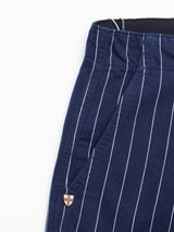 Close-up of BGpalco Toll Pants - Navy Stripe by Blue de Gênes, featuring vertical white pinstripes, detailed waistband, pocket design, and a small metal emblem near the pocket.