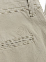Close-up of BGmenzo Vecchio Chino in Shadow Green by Blue de Gênes, showing men's fabric with a back pocket, belt loop, and an embroidered shield-shaped logo above the pocket for a subtle vintage touch.