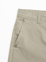 A close-up of the BGmenzo Vecchio Chino in Shadow Green by Blue de Gênes highlights the waistband, belt loop, slanted front pocket with a decorative tag, and stretch fabric with a subtle vintage finish near the pocket.