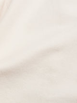 Close-up of the BGbaio Twill Blazer - Chalk by Blue de Gênes, showcasing its beige cotton twill fabric with diagonal ribbed texture, fine lines, soft folds, and subtle structure.