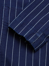 Close-up of the BGkendrick Toll Jacket by Blue de Gênes in navy stripe, featuring white vertical pinstripes and highlighting the folded cuff and pocket seam for a relaxed fit.