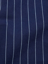 Close-up of the BGkendrick Toll Jacket by Blue de Gênes in navy stripe, showing thin vertical white pinstripes on cotton fabric—a classic, relaxed pattern perfect for this stylish worker jacket.