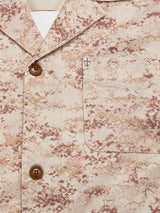 Close-up of the BGkendrick Print Jacket by Blue de Gênes, showcasing its beige and brown camo pattern, brown buttons, and a front chest pocket with a small embroidered cross emblem.