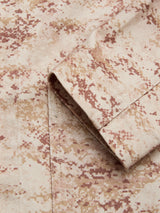 Close-up of the BGkendrick Print Jacket – Multi Pattern by Blue de Gênes, featuring a beige cotton twill fabric with brown and tan camo workwear print, highlighting the folded sleeve's edge and seam.