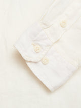A close-up of the cuff of the Blue de Gênes BGenric Hope L/S Shirt in Chalk, showing two cream-colored buttons, laid flat on a matching white background.