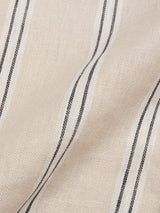 Close-up of the Pale Khaki BGcody Fling Shirt by Blue de Gênes, showing beige linen fabric with a subtle herringbone texture and evenly spaced black and white vertical stripes, gently folded to create soft shadows.