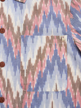 Close-up of the Blue de Gênes BGponti Kala S/S Shirt, featuring a tribal-inspired multi-colored zigzag ikat pattern, chest pocket, side brown buttons, and crafted from 100% cotton.