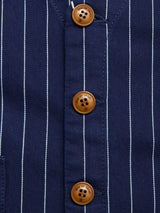 Close-up of the BGlumen Toll Gilet - Navy Stripe by Blue de Gênes, showing its navy cotton fabric with thin white stripes and three brown buttons sewn vertically along the main seam, evoking worker-inspired style.