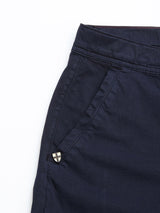 Close-up of the upper section of BGmenzino Vecchio Shorts - Dark Navy by Blue de Gênes, highlighting the waistband, side pocket, and a small black-and-white checkered tag near the pocket opening against a white background.