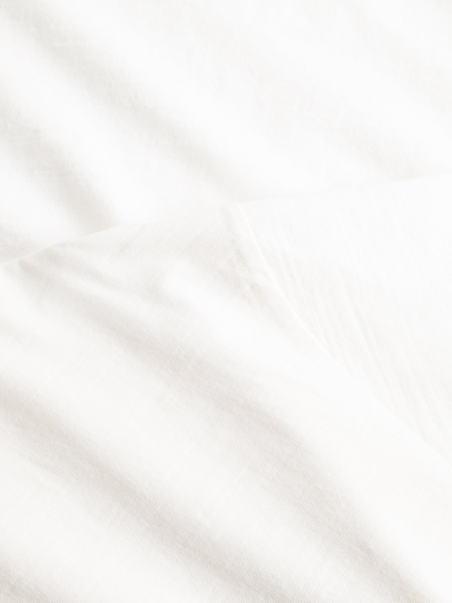 Close-up of the BGoscar T-Shirt - Snow Fall by Blue de Gênes, featuring softly textured 100% cotton fabric with gentle folds and subtle shadows for a clean, minimal look.