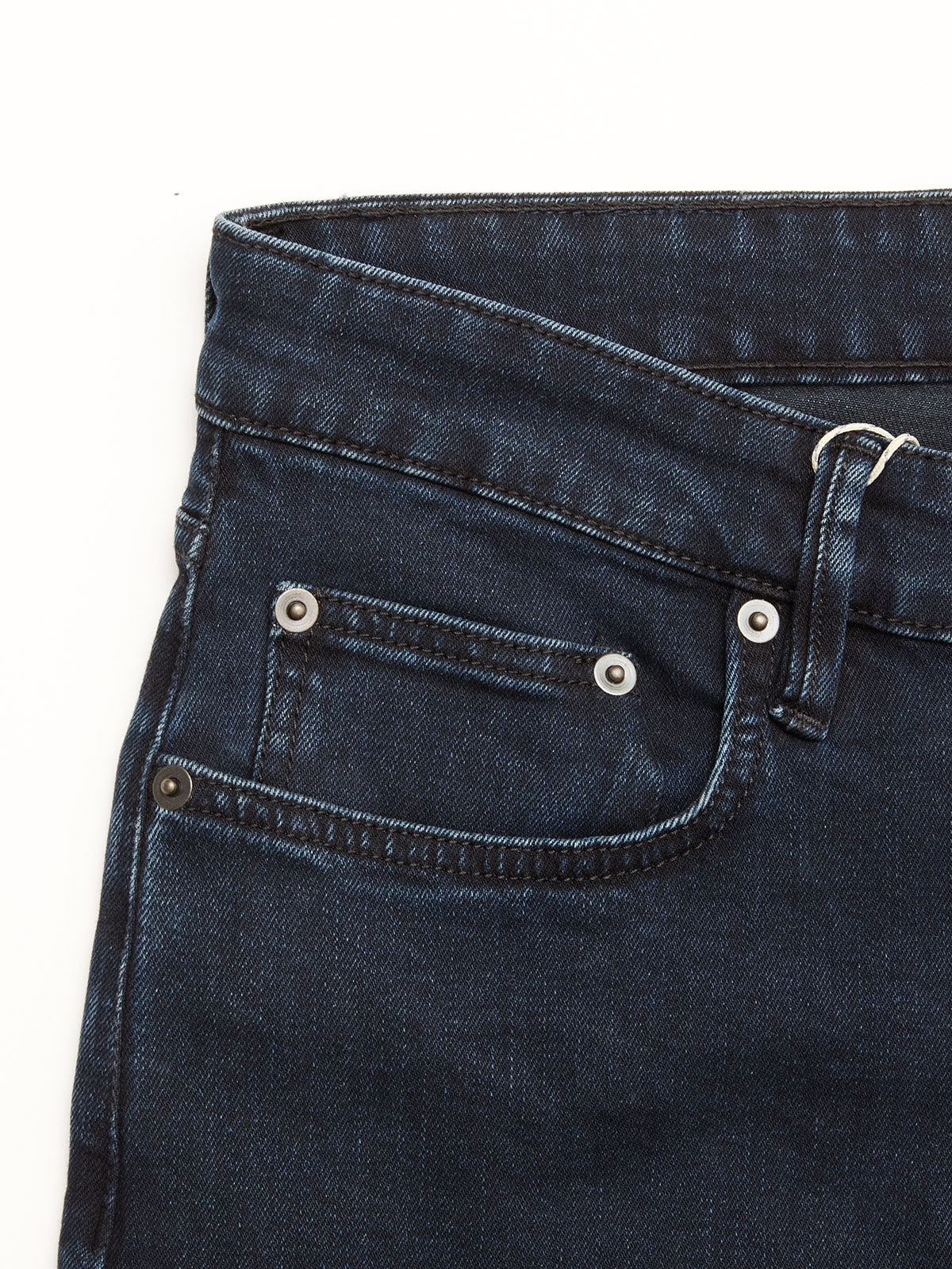 Close-up of the BGvinci Black OD Jeans by Blue de Gênes in blue black denim, highlighting the waistband, belt loop, front pocket, and coin pocket with metal rivets; crafted from comfort stretch denim against a white background.