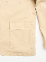 Close-up of the Blue de Gênes BGnorly Rodas Blazer in pale khaki, featuring a relaxed fit in a cotton hemp blend, with a large left front flap pocket and part of the right long sleeve against a white background.