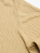 Close-up of the Blue de Gênes BGyale Slubby Crewneck Knit in Pale Khaki, showcasing its intricate stitching, textured knit fabric, and a glimpse of the sleeve on the right.