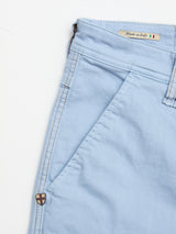 Close-up of Blue de Gênes BGpaulo Pavia Pant in Blue Fog: light blue cotton stretch chinos with front pocket, belt loop, brown stitching, shield emblem, and a “Made in Italy” tag with Italian flag on the inner waistband.