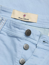 Close-up of BGpaulo Pavia Pant - Blue Fog by Blue de Gênes, featuring a red and white shield label and three logo-engraved metal buttons on the fly, crafted from premium cotton stretch fabric for comfort.