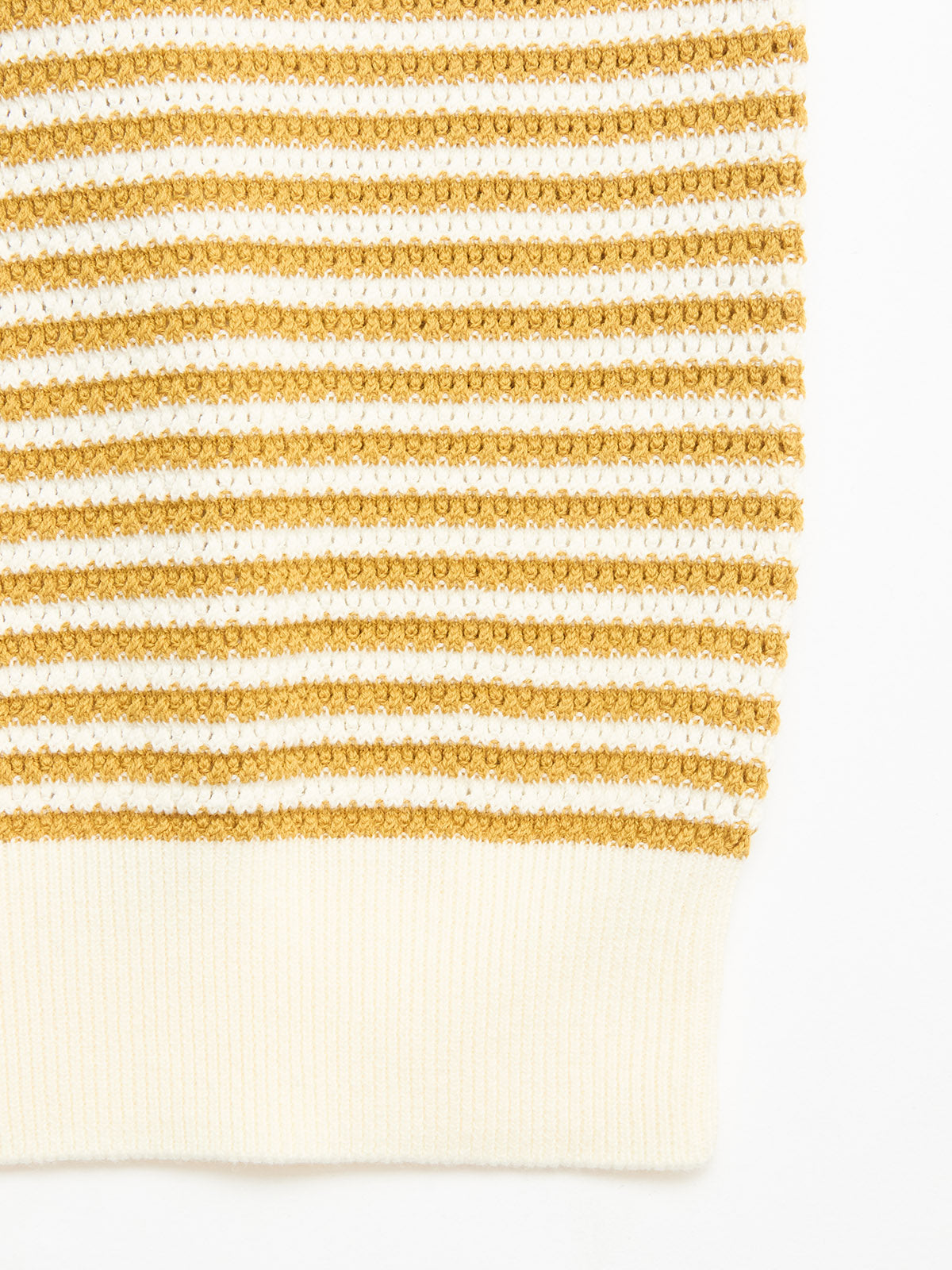 Close-up of the BGbob Knit Polo - Sunflower by Blue de Gênes, showcasing cotton knit fabric with horizontal mustard yellow and white stripes, a textured pattern, and a ribbed white hem.