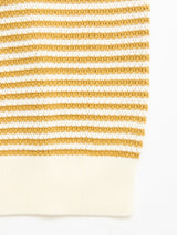 Close-up of the BGbob Knit Polo - Sunflower by Blue de Gênes, showcasing cotton knit fabric with horizontal mustard yellow and white stripes, a textured pattern, and a ribbed white hem.