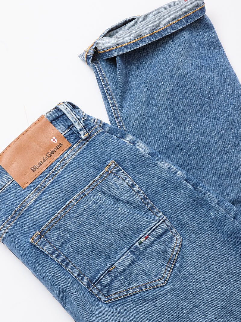 The Vinci Pala Used V2 Jeans by Blue de Gênes are regular fit, denim blue jeans in comfort stretch fabric, featuring a brown leather brand patch. Shown laid flat on a white background, highlighting the back pocket and waistband.