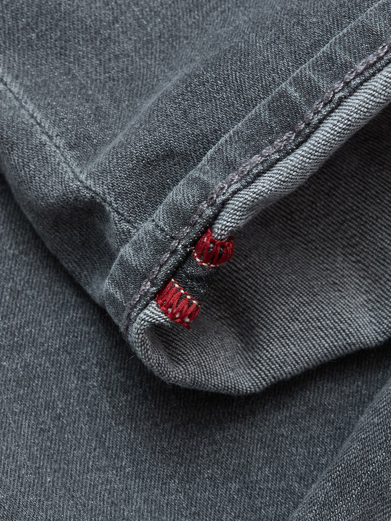 Close-up of the hem on Blue de Gênes Repi Giulio Light V2 Jeans in grey denim, featuring detailed stitching, a subtle red inner seam thread, and visible texture in the comfort stretch fabric.