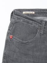 Close-up of the front pocket area of Blue de Gênes Repi Giulio Light V2 Jeans in grey denim, featuring a small red and white shield patch and a Made in Italy label, crafted from comfort stretch fabric for style and ease.