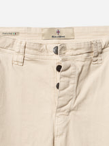Close-up of the waist and fly of BGpaulo Pavia 1 V2 Chino - Ecru pants by Blue de Gênes in stretch cotton, with three metal buttons, belt loops, and a label showing "Blue de Gênes," "Made in Italy," and an Italian flag.
