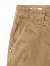 Close-up of the Paulo Pavia 1 V2 Chino in Fudge by Blue de Gênes, crafted from cotton stretch fabric. Features include a waistband with belt loops, front pocket, Italian flag Made in Italy label, and partial stitched emblem near the pocket.