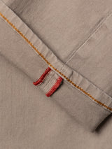 Close-up of the BGpaulo Pavia 1 V2 Chino - Fungi by Blue de Gênes, featuring beige cotton stretch fabric with golden-yellow stitching and two red bar tacks, reminiscent of details from vintage military pants or selvedge jeans.