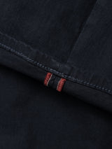 Close-up of Midnight Blue BGpaulo Pavia 1 V2 Chino by Blue de Gênes: dark denim fabric with a seam, visible stitching, and refined red and white thread detail near the hem—signature military-inspired style.