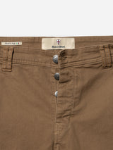 Close-up of BGpaulo Pavia 1 V2 Chino - Fudge pants by Blue de Gênes, featuring three metal buttons, front pockets, belt loops, and a label with Italian and shield logos. Inspired by vintage military pants. Made in Italy.