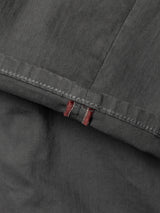 Close-up of Blue de Gênes BGpaulo Pavia 1 V2 Chino in Charcoal, featuring dark gray stretch cotton fabric and vintage military-inspired stitching with two vertical red stitches near the hem.