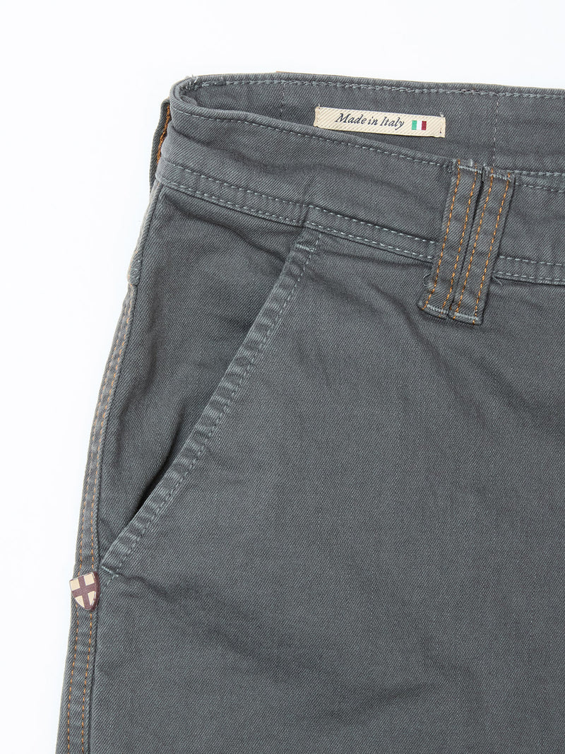 Close-up of Blue de Gênes Paulo Pavia 1 V2 Chino - Charcoal in cotton stretch, featuring a front pocket, belt loop, tan stitching, Made in Italy label with Italian flag on the waistband, and a small shield emblem near the pocket.