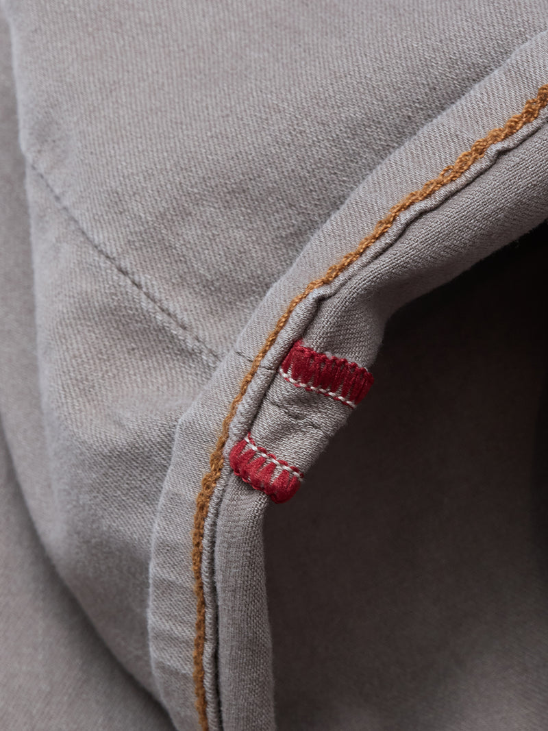 Close-up of gray Paulo Pavia 1 V2 Chino - Fungi by Blue de Gênes, featuring brown stitching and two short parallel red stitches along the seam.