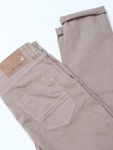 The Paulo Pavia 1 V2 Chino - Fungi by Blue de Gênes is neatly folded, displaying its back pocket, belt loops, and tan leather brand patch on the waistband against a white background.