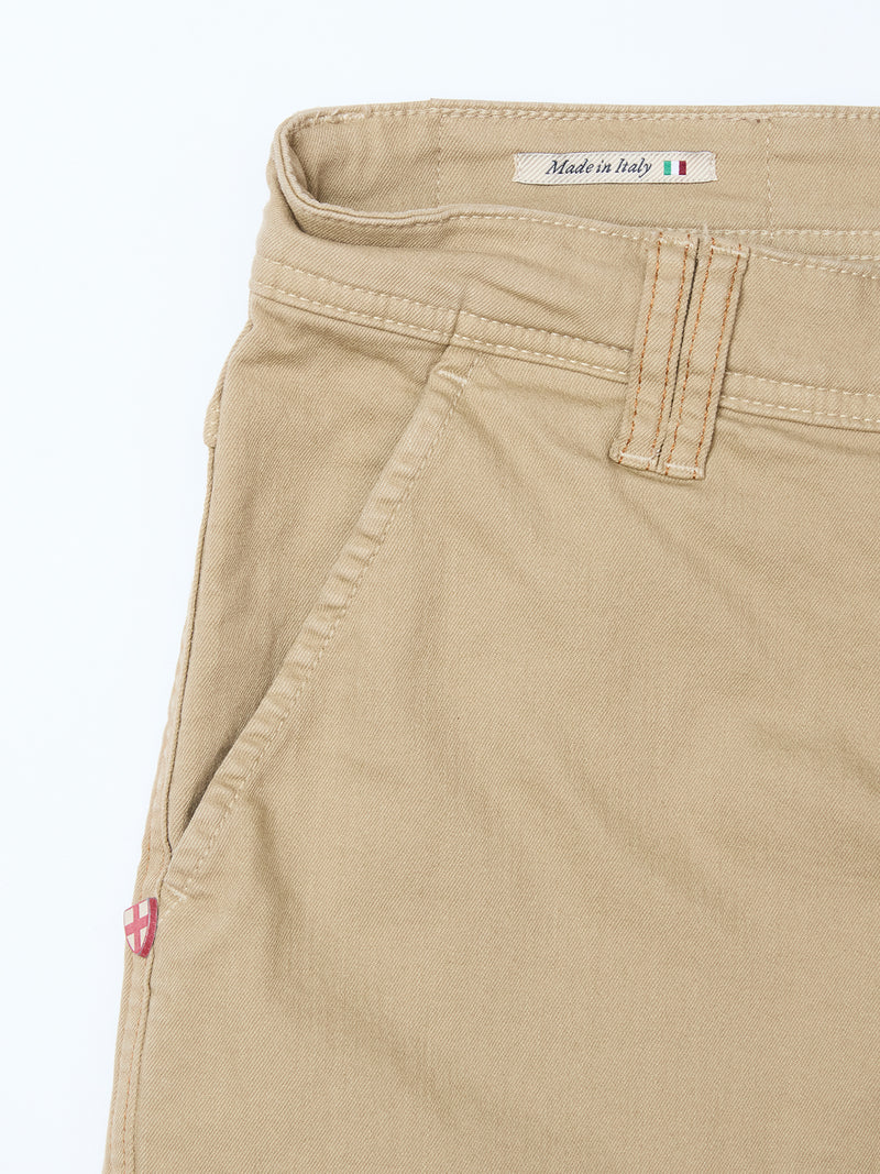 Close-up of Blue de Gênes Paulo Pavia 1 V2 Chino in khaki shows a front pocket, belt loop, visible stitching, Made in Italy label with Italian flag inside the waistband, and a small red and white shield logo near the pocket.