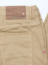 Close-up of Paulo Pavia 1 V2 Chino in khaki by Blue de Gênes, featuring tan stretch cotton, visible stitching, a back pocket, and a brown leather patch with the brand logo and a red and white shield emblem.