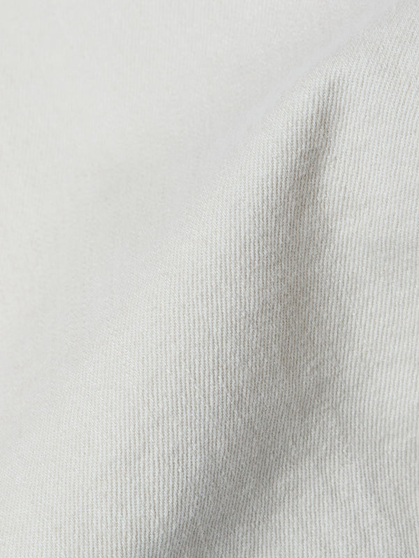 Close-up of Blue de Gênes BGpaulo Pavia 1 V2 Chino in Ecru: light beige stretch cotton fabric with soft diagonal lines and gentle folds, evoking the drape and look of vintage military-inspired pants.