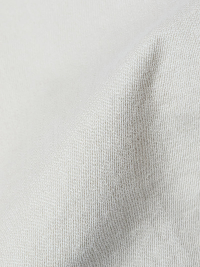 Close-up of Blue de Gênes BGpaulo Pavia 1 V2 Chino in Ecru: light beige stretch cotton fabric with soft diagonal lines and gentle folds, evoking the drape and look of vintage military-inspired pants.